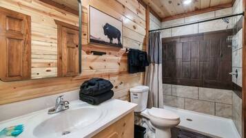 Een houten badkamer met een badkamerkastje, toilet en douche.