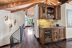 A spacious kitchen with wooden cabinets, a stone backsplash, and a built-in wine cooler. - For486 5 Bedroom Home (Vail)