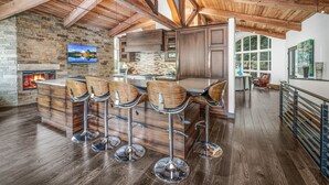 A spacious kitchen with a high ceiling, a stone wall, and a large window. - For486 5 Bedroom Home (Vail)