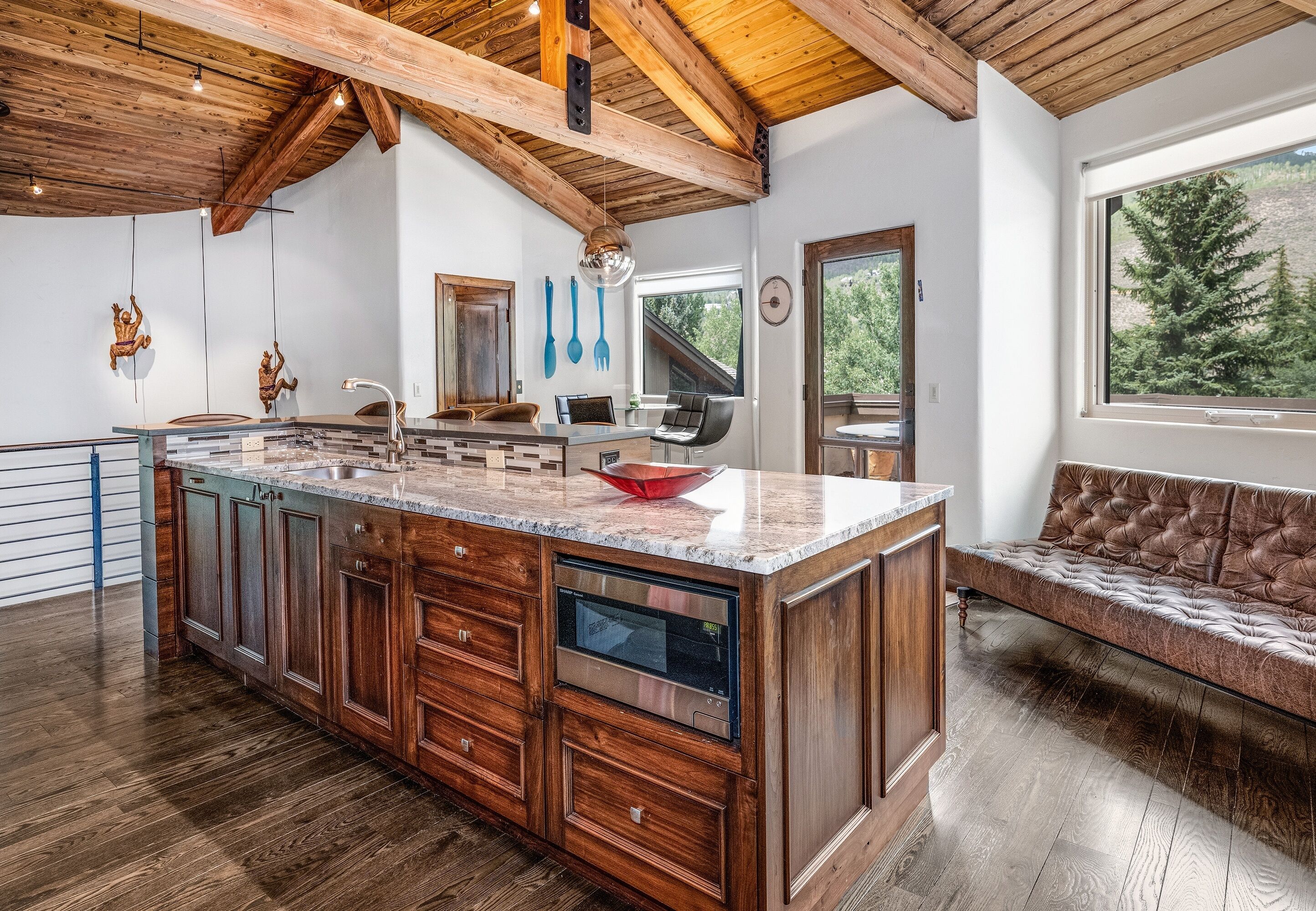 Una cocina espaciosa con una isla grande, armarios de madera y lavavajillas integrado.