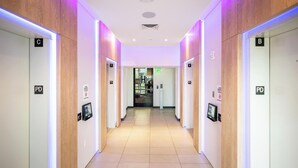 A modern hotel corridor with illuminated signs for rooms A, B, C, D, and E, and a digital display for room information. - 17th floor skyline retreat in Downtown Miami rooftop pool, coworking lounge and self check-in (Miami)
