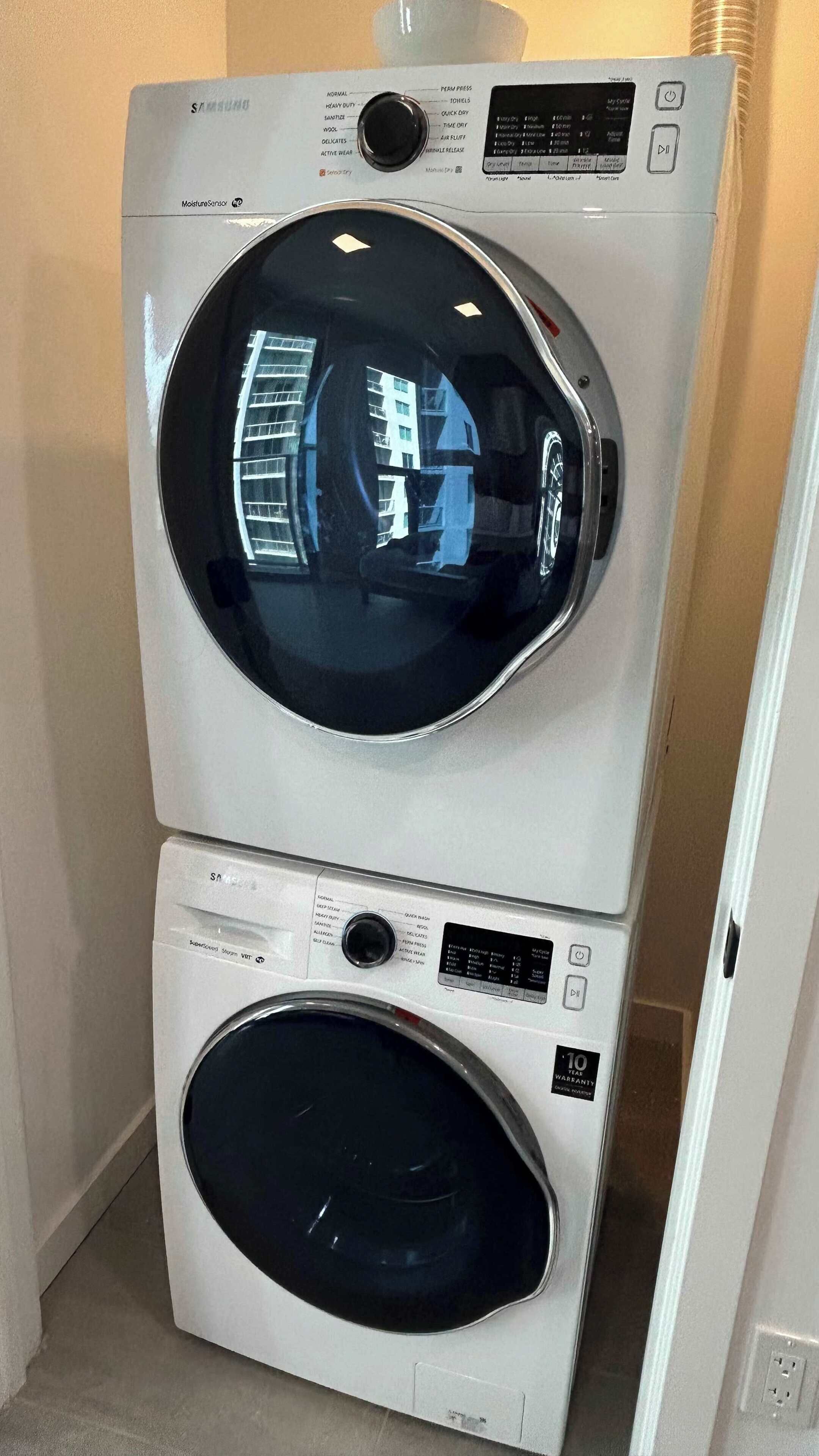 Uma máquina de lavar e secar empilhadas, com painel de controle e sensor de umidade.