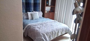 A bedroom with a bed, a nightstand, a lamp, and a window with curtains. - P. H. PRIVATE PATIO W/ THERMO TUB./POOL, 1 BLK TO RESTRNT & MRKT, CLOSE TO BEACH (Playa del Carmen)