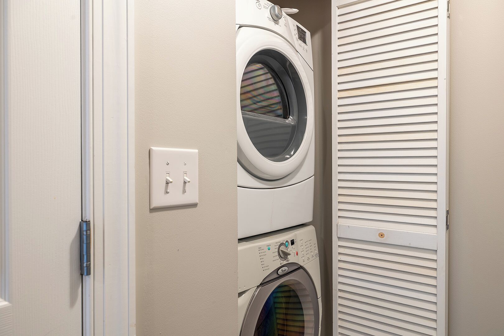 A laundry room with two stacked washing machines and a dryer.