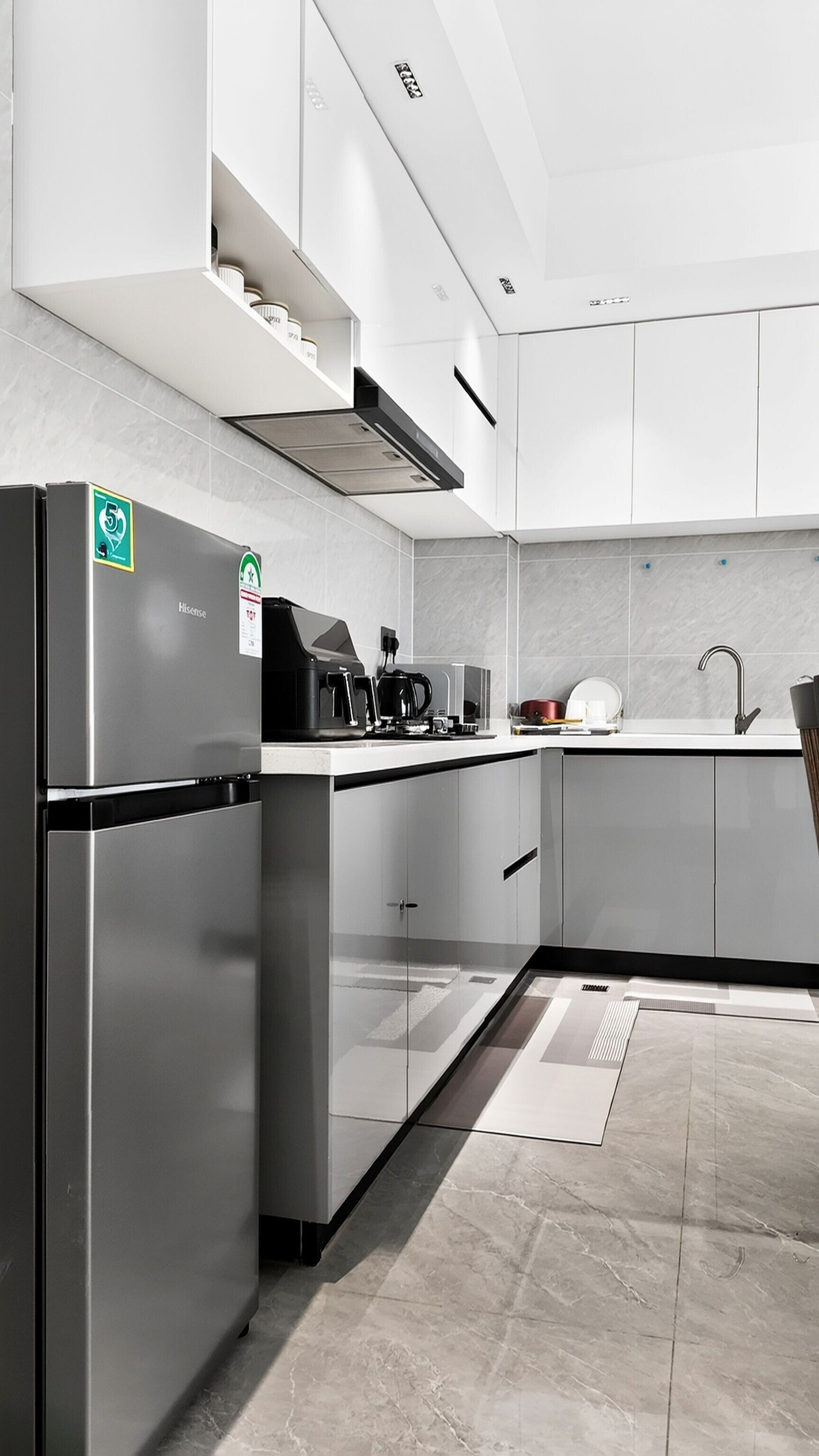 Una cucina moderna con elettrodomestici in acciaio inossidabile, una macchina da caffè e un lavandino.