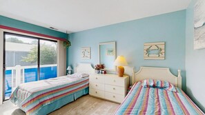 A bedroom with two beds, a dresser, a lamp, and artwork on the walls. - East of the Sun 39866 E Sun Dr 327 (Fenwick Isle)