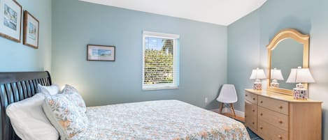 Un dormitorio con cama, cómoda y ventilador de techo.