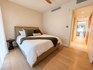 A bedroom with a bed, bedside table, and a view of the hallway. - ELAIA Luxury Voula Residence with Private Pool on Athens Riviera (Voula)
