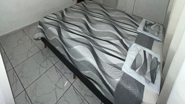 A bedroom with a bed, a ceiling fan, a wardrobe, and a door. - BEST VIEW OF BICA BEACH (Rio de Janeiro)