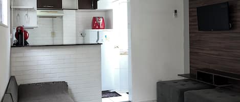 Una sala de estar moderna con un sofá, un televisor y un ventilador de techo.