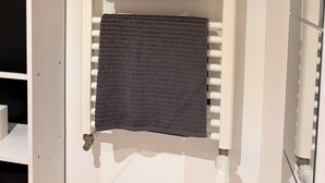 A bathroom with a white towel rack holding two towels, a small potted plant, and a mirror. - Detached studio apartment across from Riquier Station, with a beautiful view of the hills of Nice (Nice)