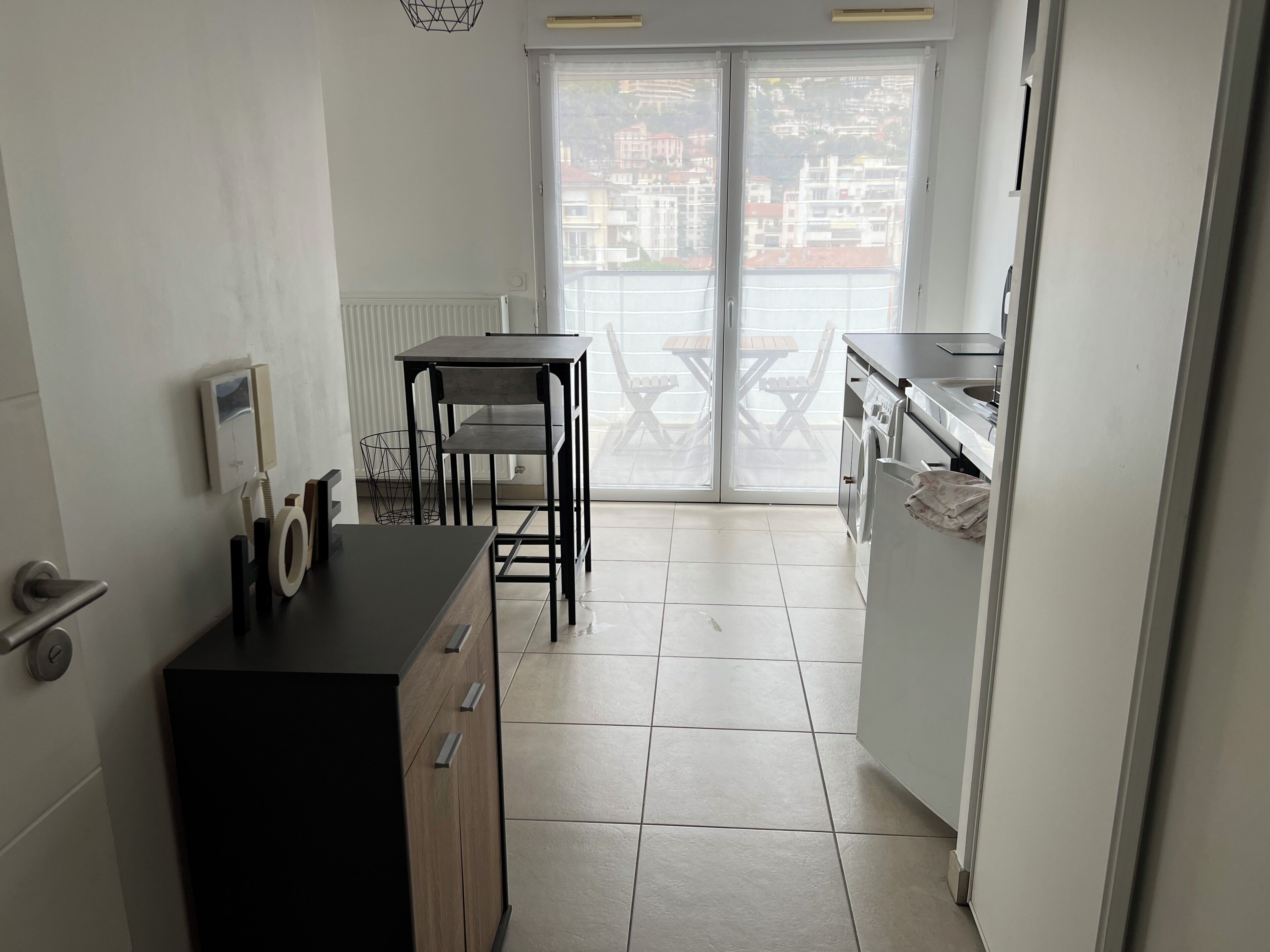 Una cocina compacta con una mesa y sillas, horno integrado y vistas a través de un ventanal.