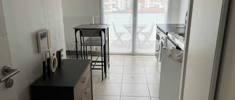 Una cocina compacta con una mesa y sillas, horno integrado y vistas a través de un ventanal.