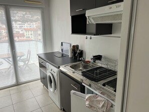Eine moderne Küche mit integriertem Waschmaschine, Spüle und Geschirr-Abtropfgestell.