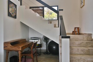 Ein modernes Interieur mit einer Treppe, einem Schreibtisch und einem Ventilator.