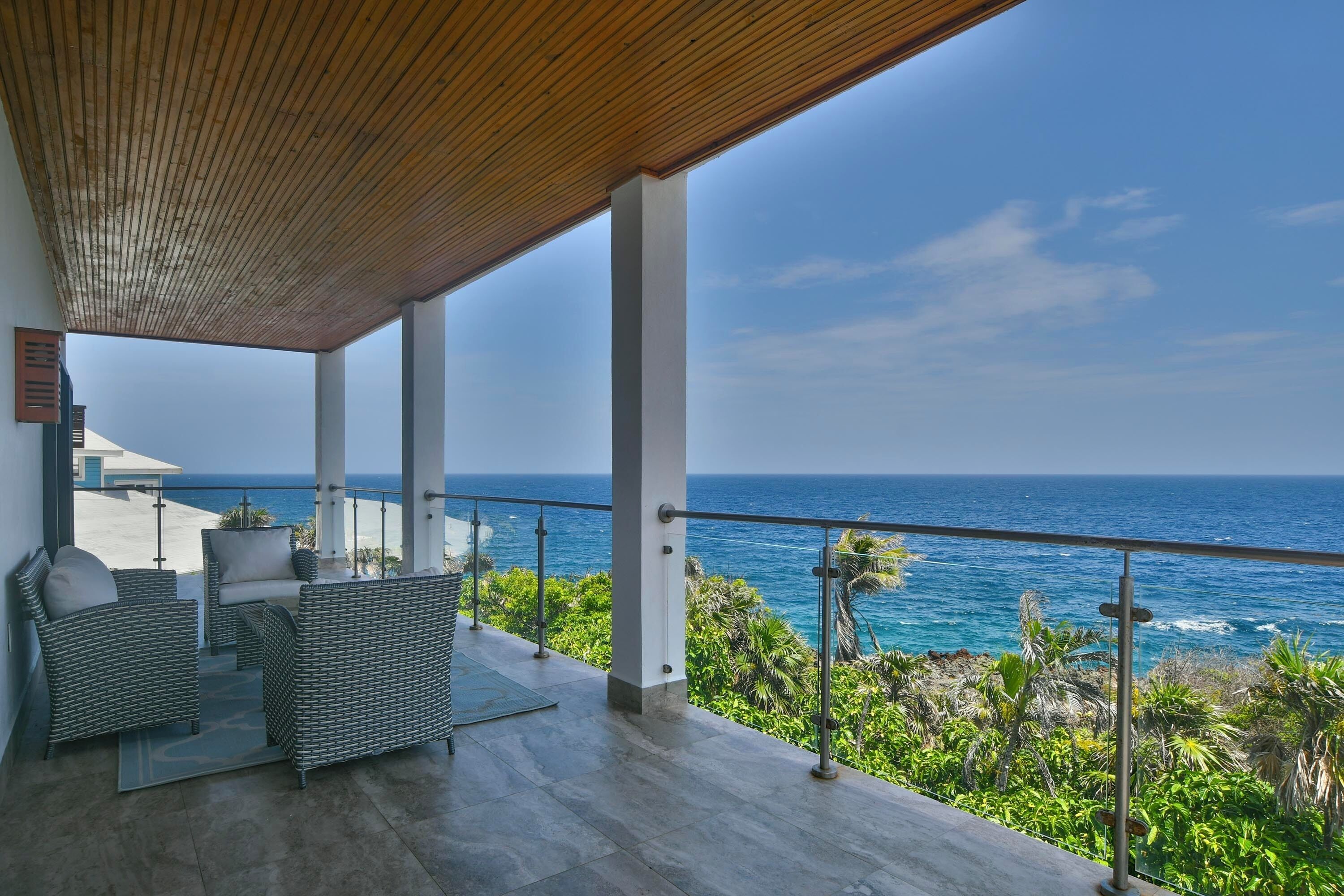 A covered outdoor seating area with a view of the ocean.