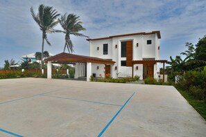 A modern two-story building with a covered patio area. - Casa Tranquilidad 3-bed by Island House Vacation Rentals (West Bay)