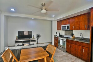 A modern kitchen with wooden cabinets, a built-in microwave, and a gas stove. - Casa Tranquilidad 3-bed by Island House Vacation Rentals (West Bay)