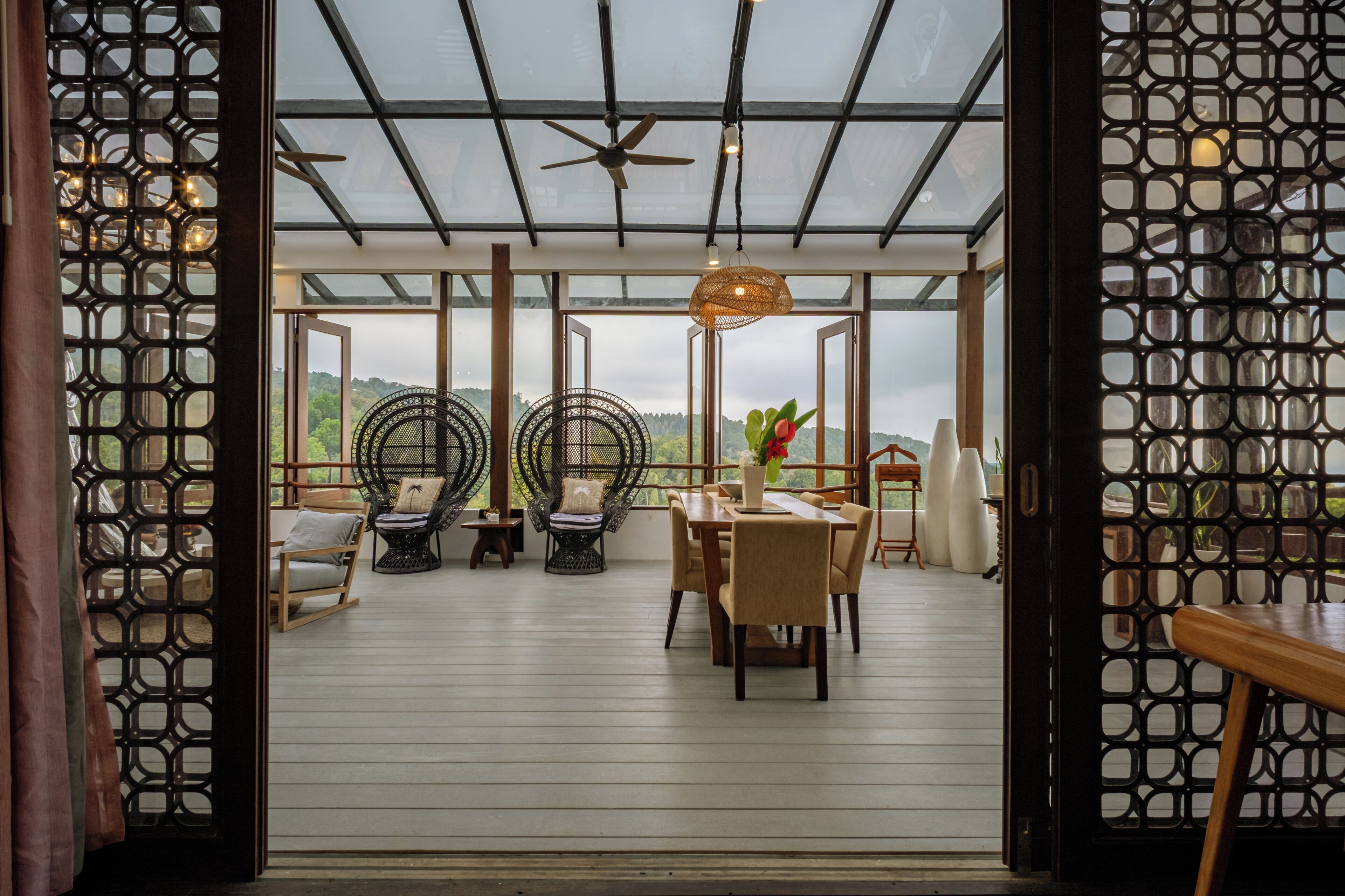 An open-plan living area with a glass ceiling, wooden flooring, and a view of the outdoors.