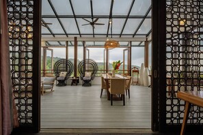 Un espacio habitable de concepto abierto con techo de cristal, suelo de madera y vistas al exterior.
