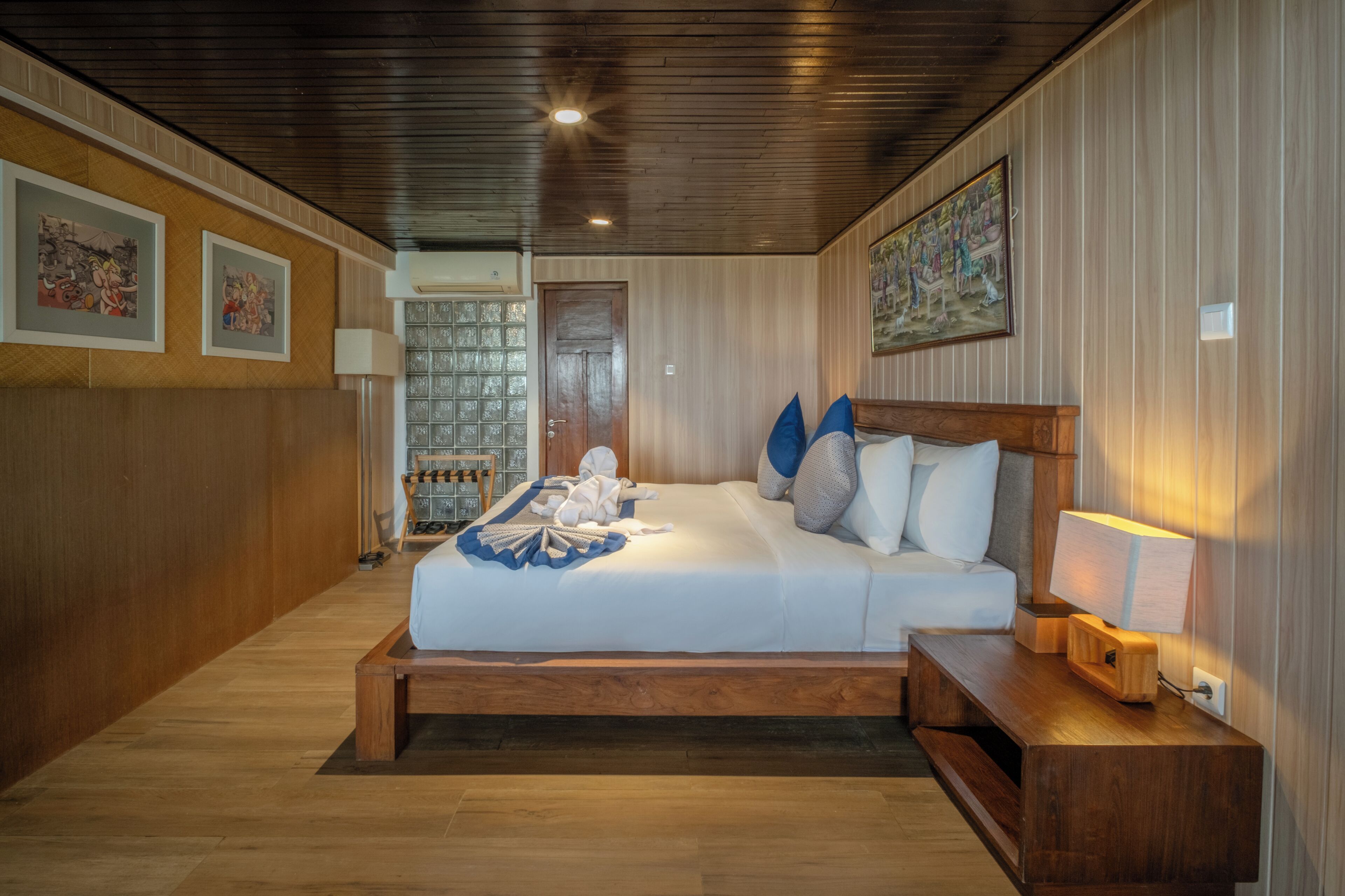 Une chambre à coucher avec un lit en bois, une table de chevet, une lampe et une porte à panneaux de verre.