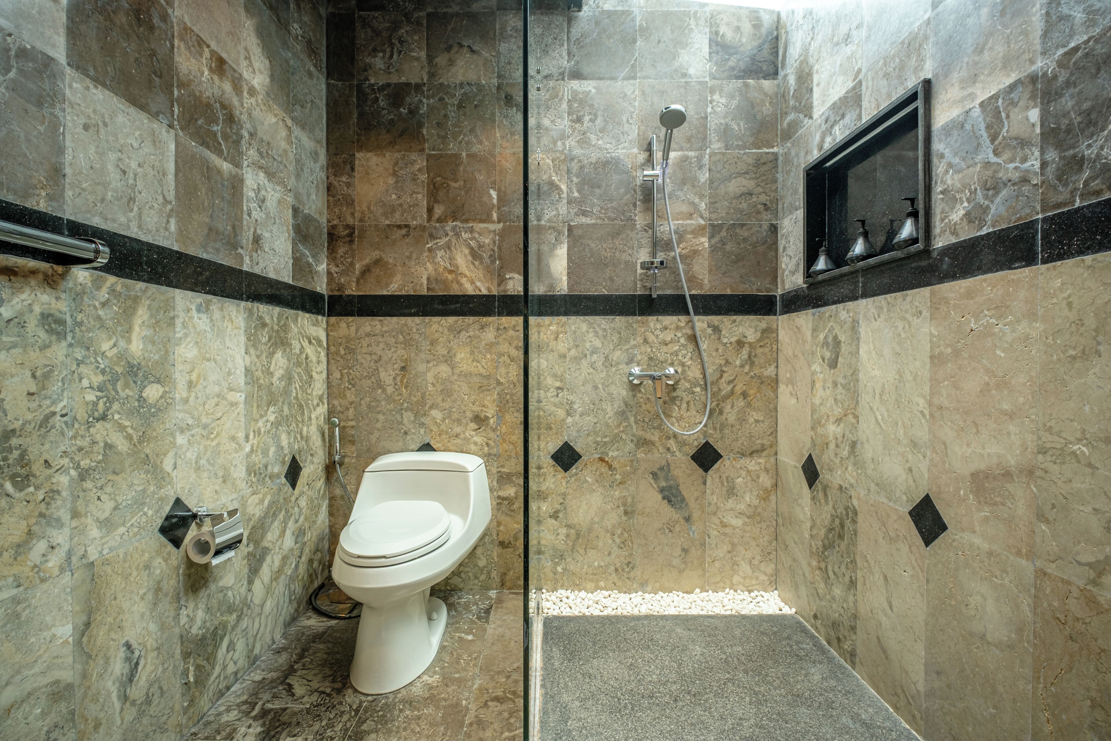A bathroom with a toilet, a shower, and a sink.