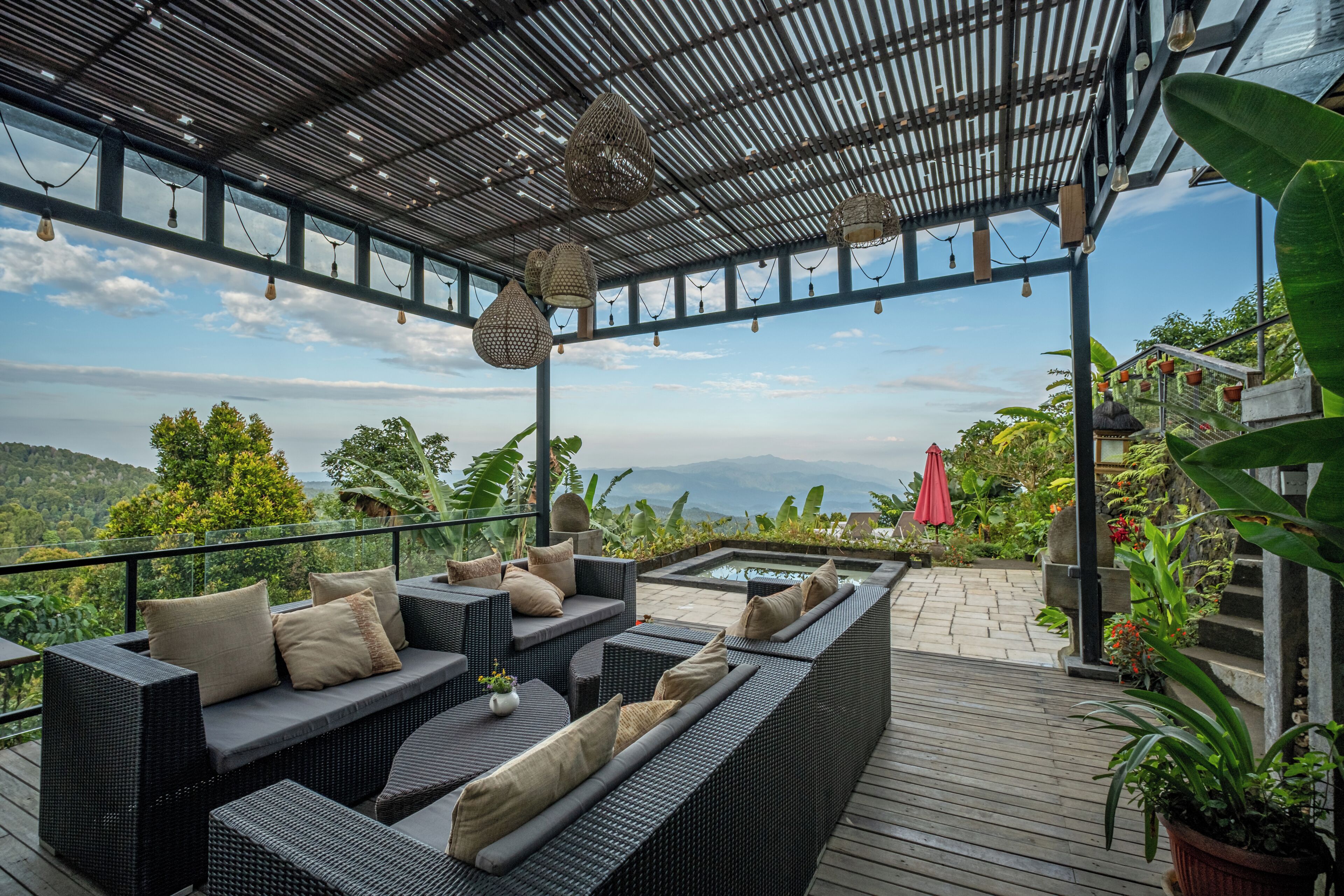 A covered outdoor seating area with wicker furniture and a view of the mountains.