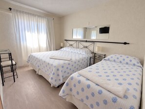 Una habitación de hotel con dos camas, un escritorio y una silla.