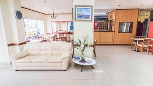 Una sala de estar con un sofá, una mesa de centro y un comedor con sillas y una mesa.