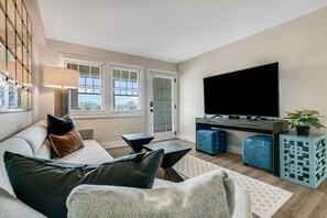 Una sala de estar moderna con un sofá, una mesa de centro, televisor y objetos decorativos.
