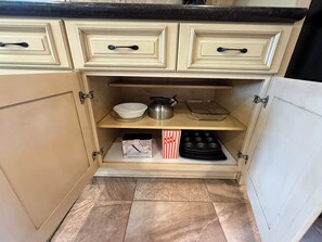 A kitchen with cabinets, a countertop, and a shelf with kitchenware. - Spacious 4-bedroom house in Ozark, near Finley Farms (Ozark)