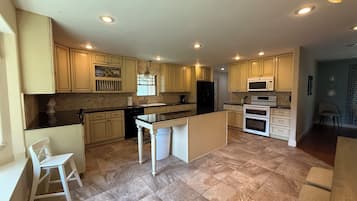 A spacious kitchen with a central island, built-in appliances, and ample counter space.
