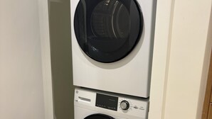 A stacked washer and dryer unit in a hallway. - Nomad Wynwood - Boutique luxury 1 bedroom+Den+2B (Miami)