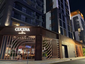 Un edificio moderno con un letrero que dice 'CUCINA', indicando un restaurante o cafetería.