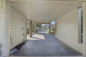 A covered walkway leading to a parking area with a car visible in the distance. - Heron Marsh 108 Beautiful view, Litchfield by the Sea (Pawleys Island)
