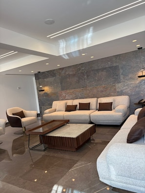 A modern living room with a sectional sofa, a coffee table, and a chair.