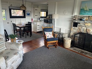 Una sala de estar con chimenea, un comedor y una cocina.