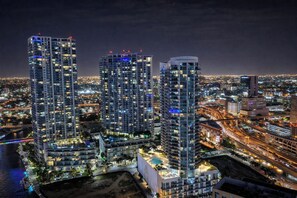 Un complex d'edificis alts amb diverses plantes, envoltat d'un entorn urbà animat de nit.