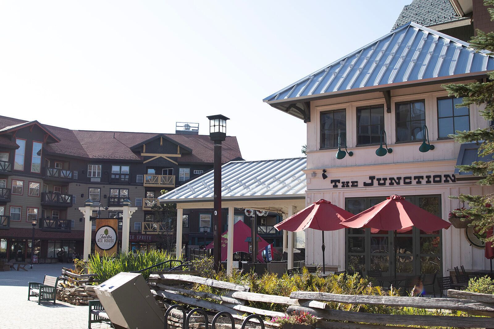 A building with a sign reading 'The Junction' and a covered outdoor seating area with red umbrellas.
