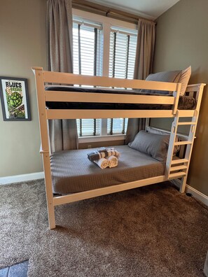 A bunk bed with a mattress, pillows, and rolled towels. There is a window with curtains, a framed picture on the wall, and a carpeted floor. - Snowshoe Village Ski-in - Ski-out Condo w/ Hot Tub (1 Br / 1 Ba) (Snowshoe)