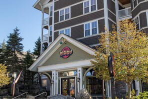 A multi-story building with a prominent pizza restaurant sign. - Newest property in our portfolio! Discounted! Snowshoe Village Ski-in - Ski-out Condo w/ Underground Parking & Community Hot Tub (Snowshoe)