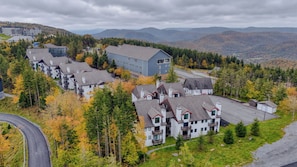 A residential area with multiple houses, a large building, and a winding road. - Sunset facing slopeside condo and pet friendly! (Snowshoe)