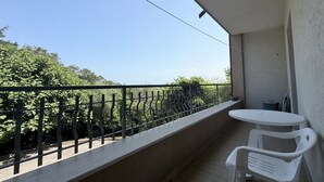 A balcony with a white table and chairs, a metal railing, and a view of greenery. - A50 - Massignano, spacious four-room apartment (Massignano)