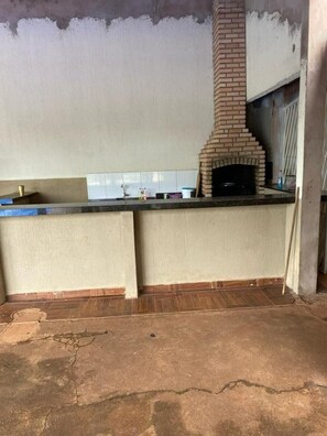 A kitchen with a brick oven, a countertop, and a tiled backsplash. - Barreirinhas Village (Barreirinhas)