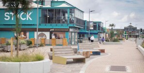 A modern building with a large sign reading 'STOCK' and a cafe named 'yolo' inside.