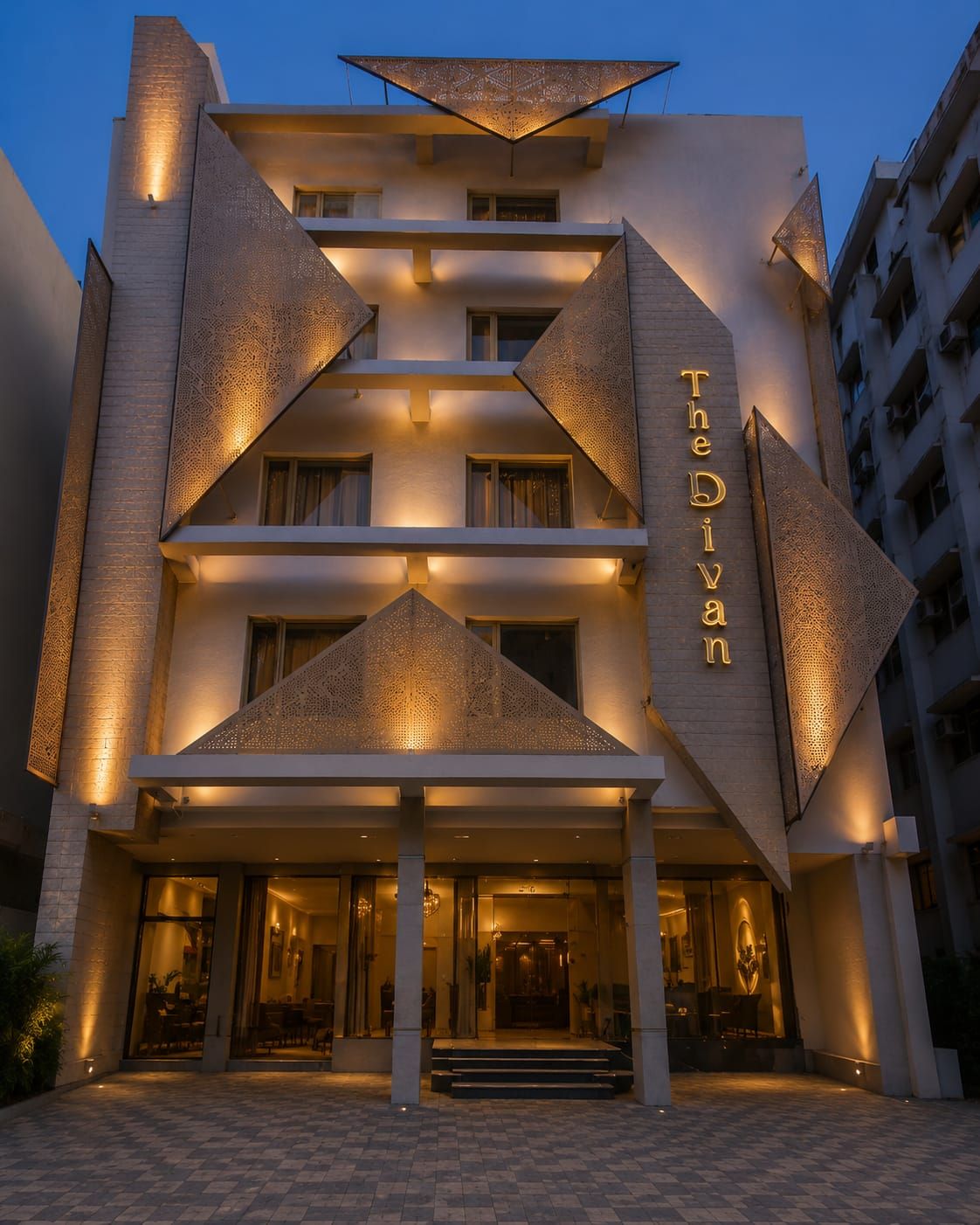 Un hôtel au design moderne, doté d’une entrée imposante avec des marches menant à une porte en verre.