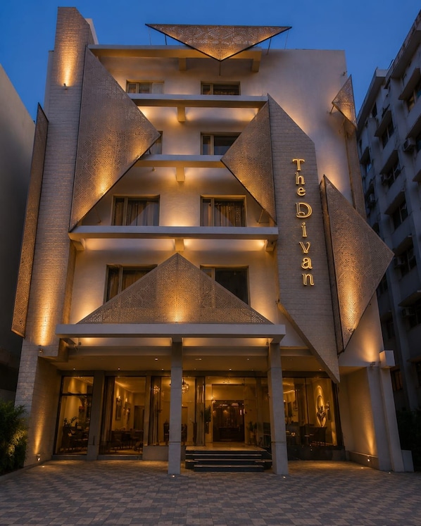 Un hotel de diseño moderno, con una entrada destacada que cuenta con escalones que conducen a una puerta de vidrio.