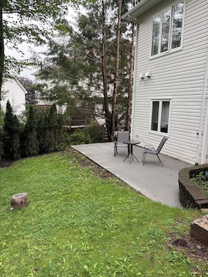 A residential property with a patio, a small table and chairs, and a garden area with grass and trees. - Nature's Retreat in Bedford (Bedford)