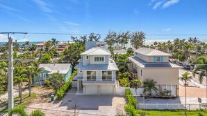 A residential area with houses, a clear sky, and a view of the ocean. - Coastal Paradise- Brand new 4 bedroom with rooftop elevator (Holmes Beach)
