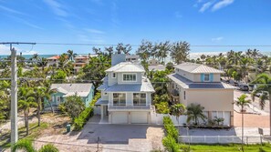 A residential area with houses, a clear sky, and a view of the ocean. - Coastal Paradise- Brand new 4 bedroom with rooftop elevator (Holmes Beach)